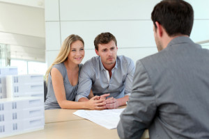 Couple in real-estate agency talking to construction planner