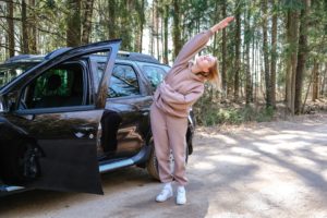 Fitness on the street travel on the road near the car on a trip.Girl doing workout in travel.Fit on the street, Health, self-care